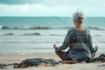 Senior Woman meditating on ocean beach