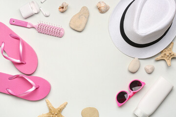 Frame made of different beach accessories, earphones, hair brush and seashells on light background