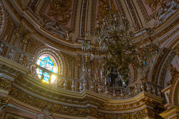 Fototapeta na wymiar メキシコ　チョルーラの教会　シャンデリアとステンドグラスから差し込む光