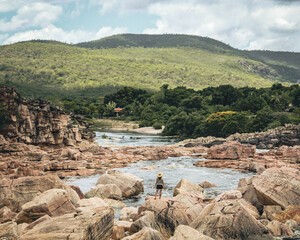 mulher caminhando em pedras no Rio Paraguaçu em Andaraí, na Chapada Diamantina, Bahia