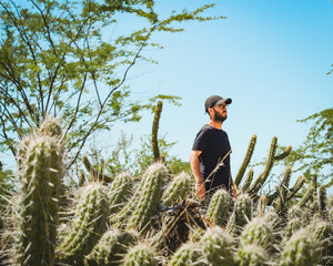 homem caminhando entre cactos da caatinga, no sert&atilde;o da bahia 