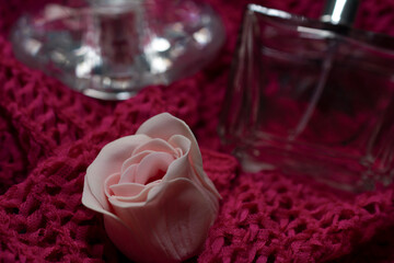 Women's perfume and a rose on a pink background.