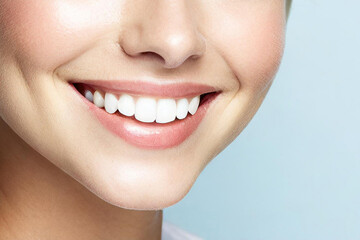 Obraz premium Dental care and health.Woman smile.Correct healthy care of white teeth with clean skin and make-up, beautiful female face,pure beauty,light blue background.