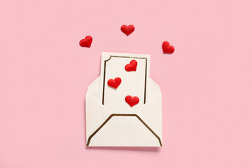 Composition with envelope, card and red hearts on pink background. Valentine's Day celebration