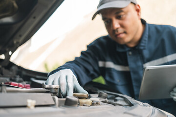 Professional car mechanic maintenance vehicle. The mechanic opens the front of the car. Checking...