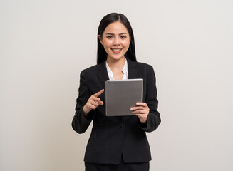 Attractive elegant young asian business woman using digital tablet standing on isolated background. Happy young latin female formal black suit holding tablet gadget working service with customer