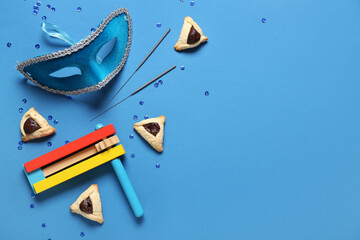 Composition with carnival mask, Hamantaschen cookies and rattle for Purim holiday on color...