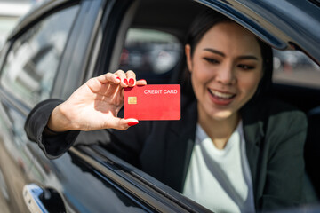 Young beautiful asian business women getting new car. Hand holding credit card payment. Car owner...