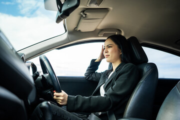 Driving during rush hour But the traffic is very congested. Angry face. Young asian businesswoman...