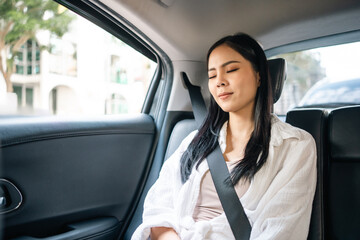 Fototapeta na wymiar Relaxing moment of beautiful woman sleeping in car back seats with safety belt. Female happy in car while traveling on the road to destination.