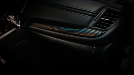 Detalles interiores en consola central de vehículo con detalles en vinilo fibra de carbono