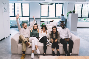 Group of happy diverse coworkers rejoicing over victory