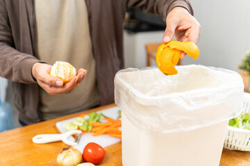 Ecology compost supply Kitchen waste recycling composter environmentally friendly. The young man throws leftover fruit peel and vegetables reduce waste