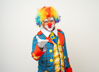 Mr Clown. Portrait of Funny comedian face Clown man in colorful uniform wearing wig standing pointing finger to camera. Happy expression amazed face male bozo in various pose on isolated background.