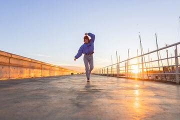 woman dancing in a port at sunset, red hair, smiling