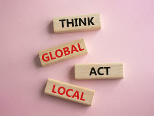 Think global act local symbol. Wooden blocks with words Think global act local. Beautiful pink background. Business and Think global act local concept. Copy space.