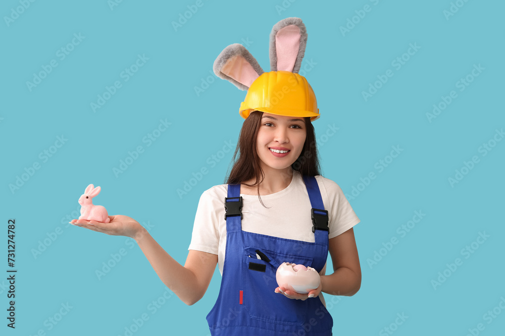 Poster female asian worker in bunny ears with easter eggs on blue background