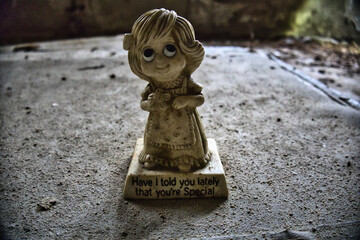 Alte Statue von einem kleinen Mädchen mit Blume in der Hand. Eingraviert ist 