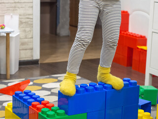 girl plays with drawn blocks of a constructor at home, A child's hand puts large colorful blocks from a children's model set