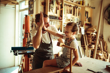 Father and daughter enjoying woodworking in a home workshop