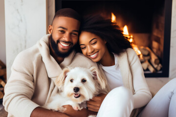 High key, Beautiful African-American couple in white sweaters cuddles with a dog while sitting in front of the fireplace