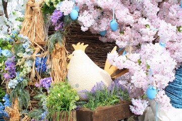 Wooden chicken, flowers and eggs decor on streets of the city. Easter decor in rustic style. Easter holiday decoration of the central square. Happy Easter concept