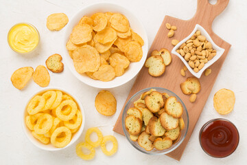 Various unhealthy snacks on concrete background, top view