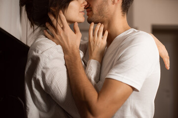 closeup kiss and hugs couple in love wearing white domestic clothes - obrazy, fototapety, plakaty