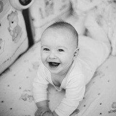 little boy smiling in his crib
