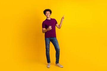 Full length photo of nice satisfied man wear trendy polo reommend buy modern technology empty space isolated on yellow color background