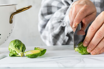 Preparing raw brussel sprouts for cooking.