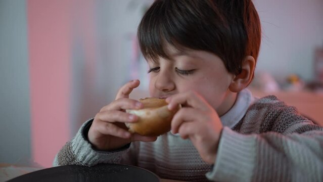 Little Boy Eating Bread at Table, Taking a Bite of Carb Food