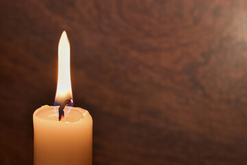 A candle burns on a dark background. Enlarged image of a candle in the dark. Created by artificial...