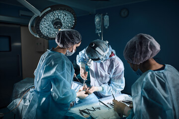 A shot of an emergency and a serious accident in the operating room, a team of surgeons makes an...