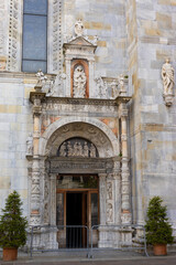 Fototapeta na wymiar Portal of the cathedral in Como, Italy. Old ancient wooden Church Door