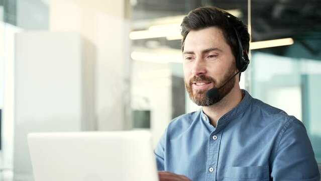 Corporate operator who works in customer support speaks on a video call using a laptop computer. Call center agent in wireless headset helping customer with complaints in office. Online consultation