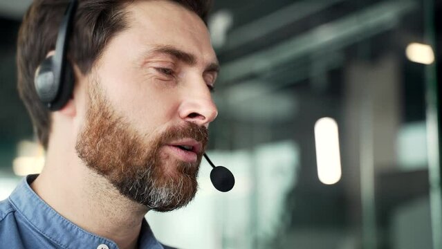 Manager who works in customer support speaks on a video call using a laptop. Call center agent operator in wireless headset helping customer with complaints in office. Online consultation. Close up