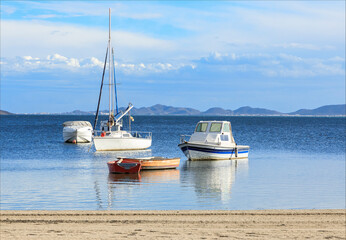 Sailing boats of different sizes by the shore