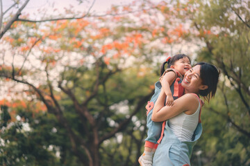 Asian mother walking with daughter in park, Parents hold the baby's in his hand , Happy family in the park evening light, Happy family concept.