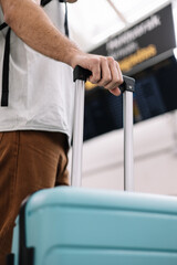closeup man in airport holding suitcase handle
