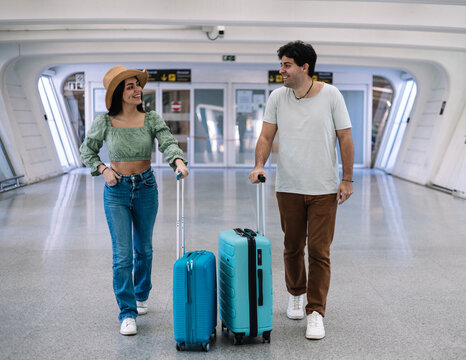 Latin couple of travelers entering the airport to begin their honeymoon