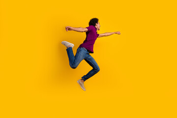 Full length profile side photo of funky crazy guy raising hand fist running forward empty space isolated on yellow color background