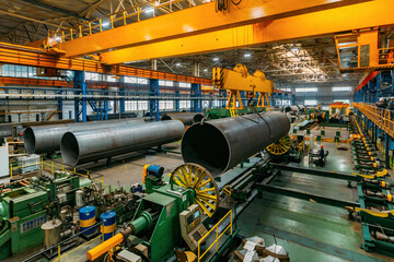 Finished pipe transportation by overhead crane in pipe factory - obrazy, fototapety, plakaty