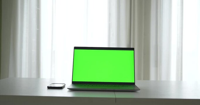 Laptop home office with green screen where you can add any image to the laptop monitor. 