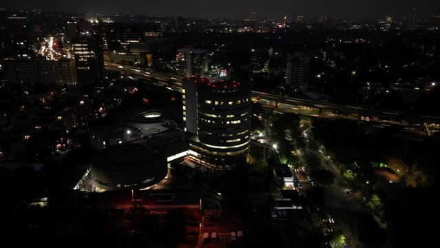 Drone timelapse of illuminated Mexico City's buildings and streets at night
