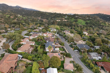 Fototapeta premium a city with hills and houses next to trees and grass