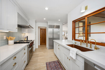 a kitchen with a sink and a large window in the middle