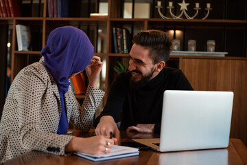 A young Muslim bussines woman and man working together in the office.