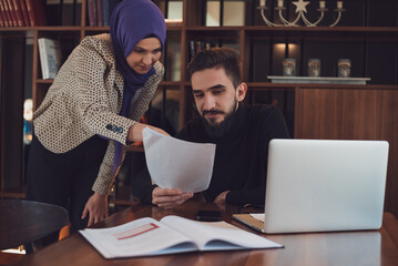 A young Muslim bussines woman and man working together in the office.