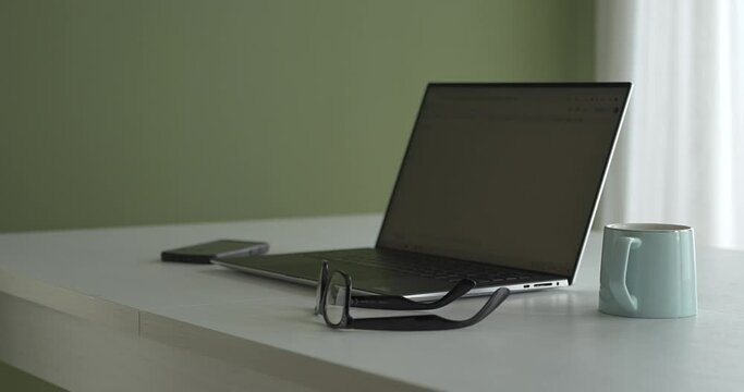 Work laptop at home next to a cup of coffee.
